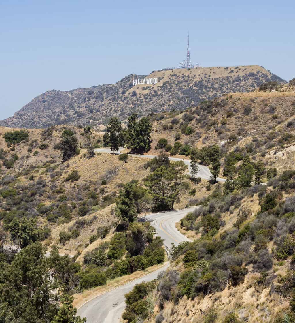 A winding street through Los Feliz with the Hollywood sign in the background