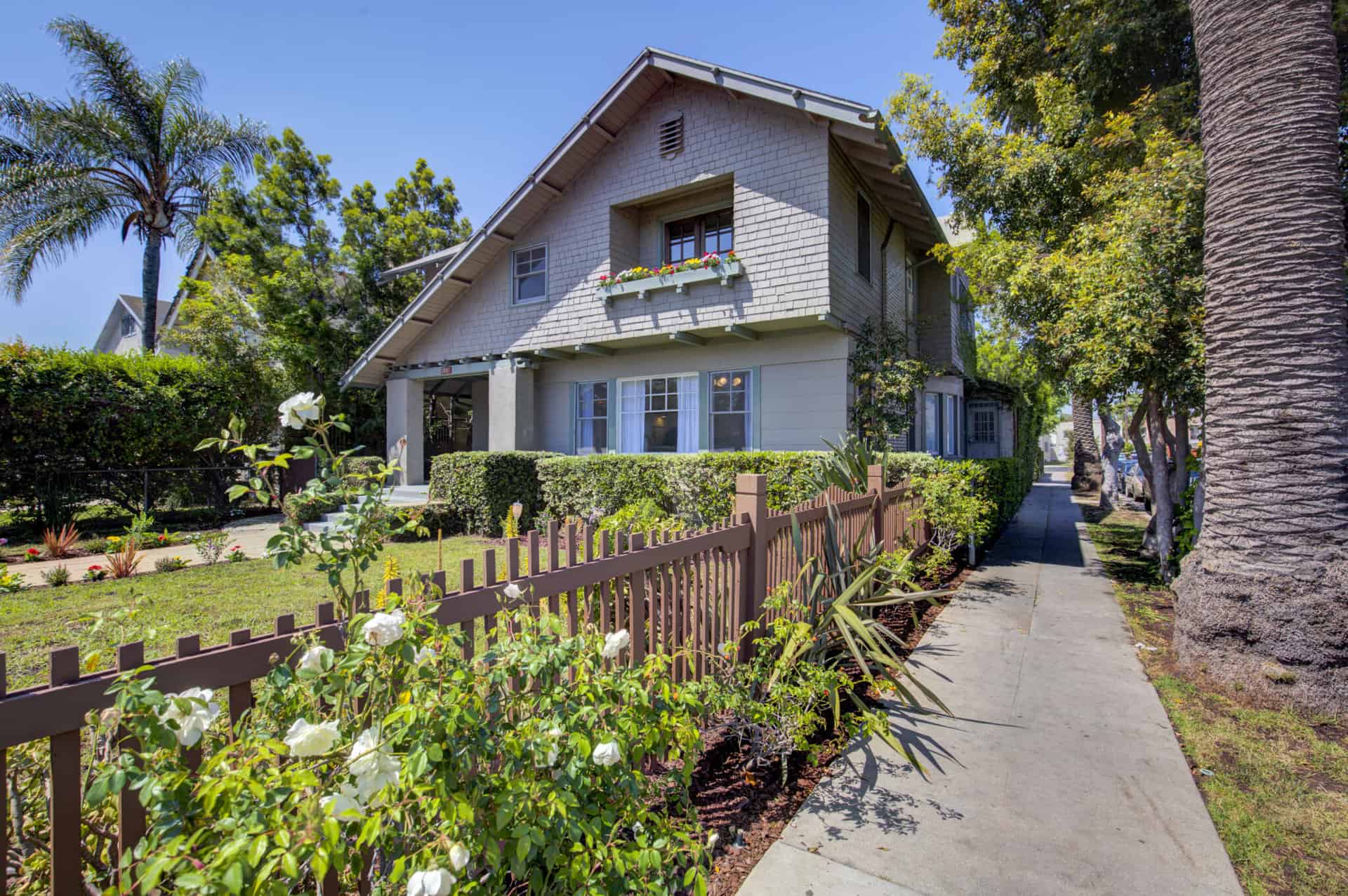 Exterior view of old craftsman home on large lot with well-manicured lawn.